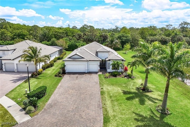 view of front of home featuring a garage, a front yard, decorative driveway, and a tile roof