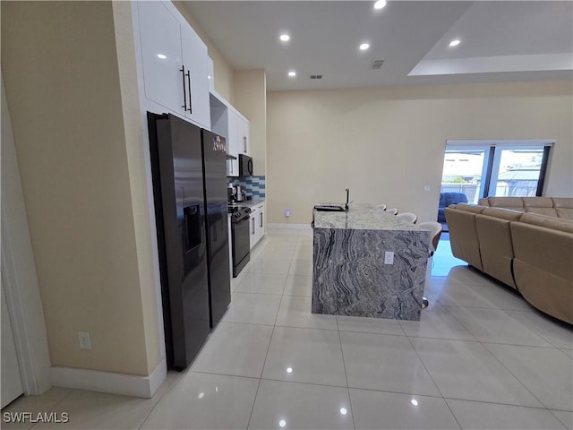 kitchen with light tile patterned floors, recessed lighting, white cabinetry, black appliances, and tasteful backsplash