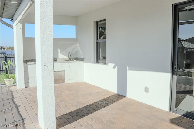 view of patio / terrace featuring fence, a sink, and area for grilling