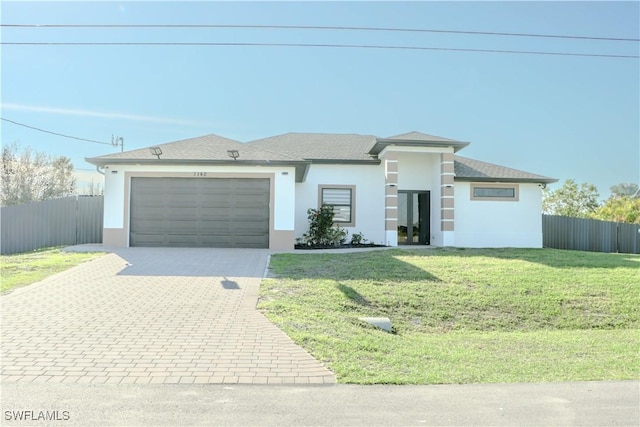 view of front of property with a garage, a front lawn, decorative driveway, and fence