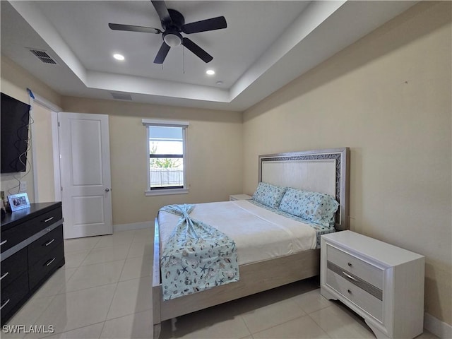 bedroom featuring light tile patterned flooring, recessed lighting, visible vents, baseboards, and a tray ceiling