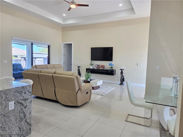 living room featuring light tile patterned floors, recessed lighting, a raised ceiling, a towering ceiling, and ceiling fan