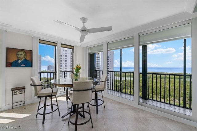 dining area featuring light tile patterned floors, a healthy amount of sunlight, ceiling fan, and a water view