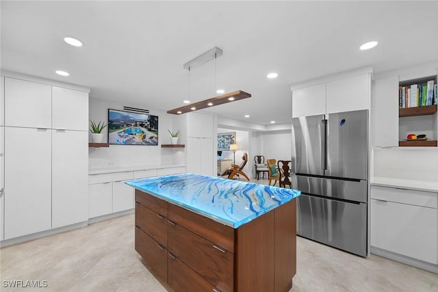 kitchen featuring a kitchen island, open shelves, freestanding refrigerator, white cabinetry, and modern cabinets