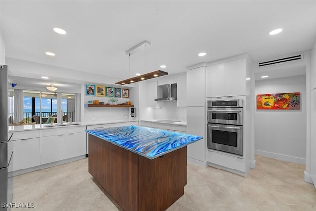 kitchen featuring visible vents, white cabinets, double oven, wall chimney exhaust hood, and modern cabinets