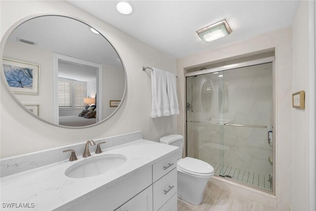 ensuite bathroom featuring visible vents, toilet, a stall shower, ensuite bathroom, and vanity