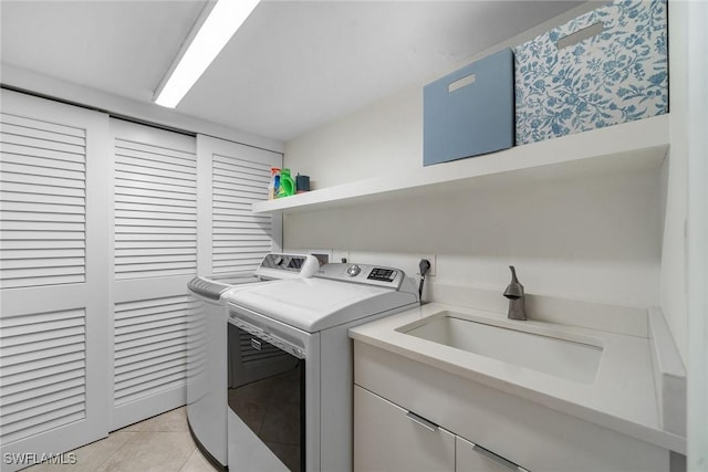 laundry area with light tile patterned flooring, laundry area, a sink, and separate washer and dryer