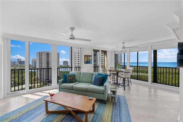 sunroom featuring a city view, a ceiling fan, and a water view