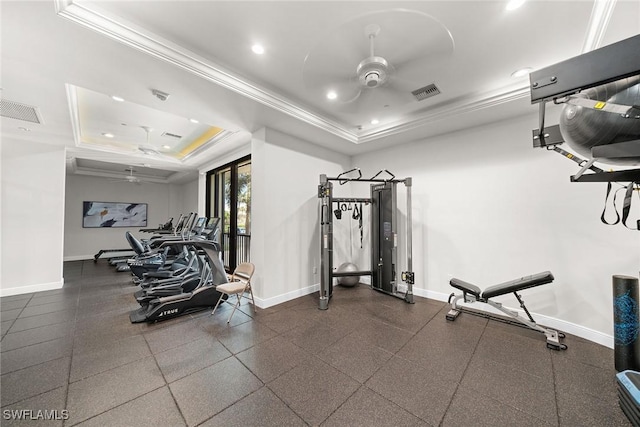 exercise room featuring a tray ceiling, ornamental molding, visible vents, and ceiling fan