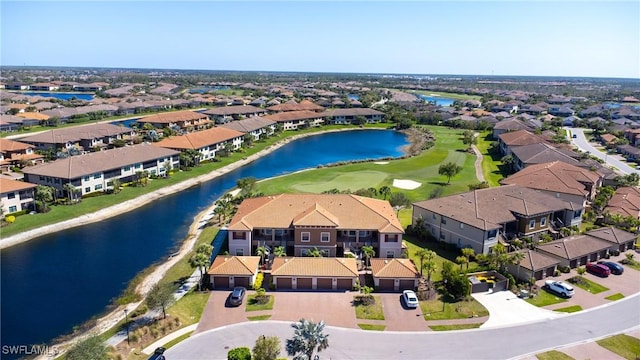 drone / aerial view featuring a residential view, view of golf course, and a water view