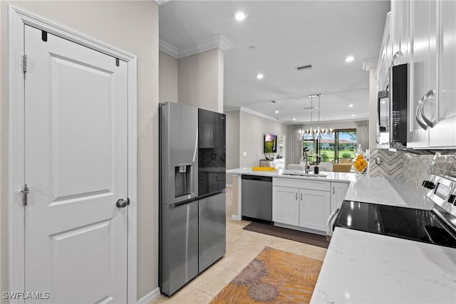 kitchen with white cabinets, appliances with stainless steel finishes, ornamental molding, a peninsula, and a sink