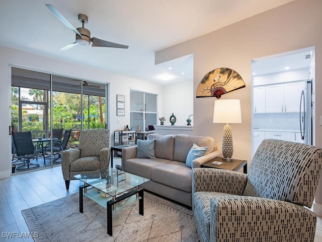 living room featuring recessed lighting, a ceiling fan, and light wood-type flooring