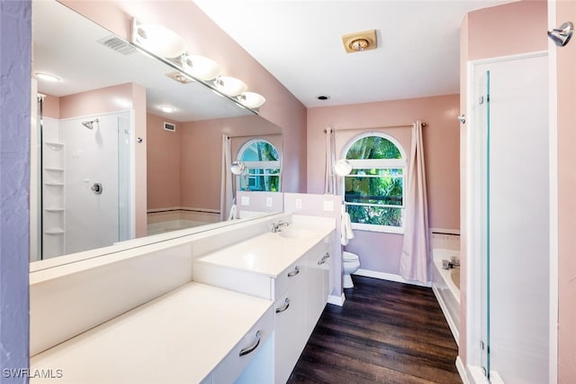 bathroom featuring vanity, wood finished floors, visible vents, a stall shower, and toilet