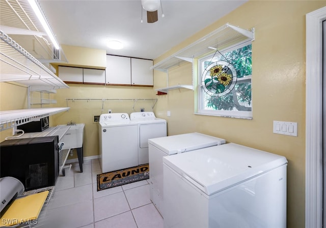 clothes washing area featuring ceiling fan, laundry area, light tile patterned floors, and washing machine and clothes dryer