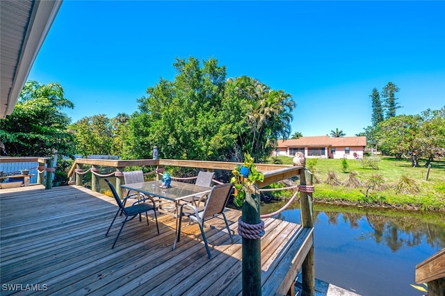 view of dock with outdoor dining area and a deck with water view