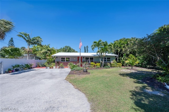 ranch-style house with a front yard and fence