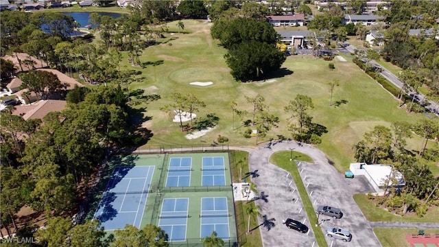 birds eye view of property with view of golf course and a water view