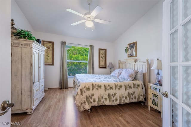 bedroom with a ceiling fan, lofted ceiling, and wood finished floors