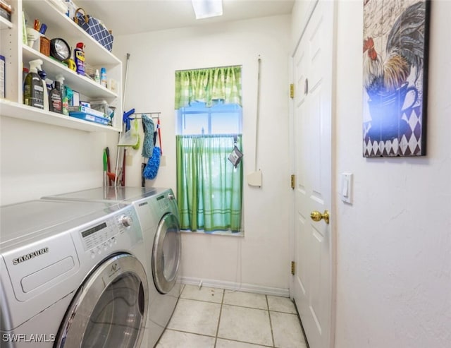 laundry area featuring washing machine and clothes dryer, laundry area, baseboards, and light tile patterned floors