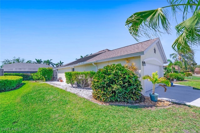 view of home's exterior with stucco siding, driveway, a lawn, and a garage