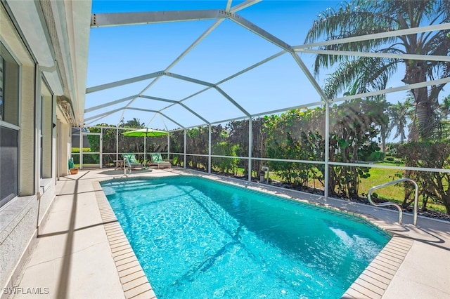 pool with glass enclosure and a patio