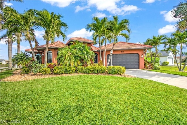 mediterranean / spanish house with driveway, a front lawn, an attached garage, and a tiled roof