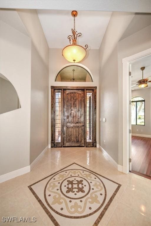 foyer entrance with a high ceiling and baseboards