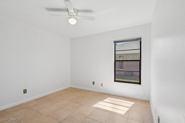 unfurnished room featuring light tile patterned flooring, a ceiling fan, and baseboards