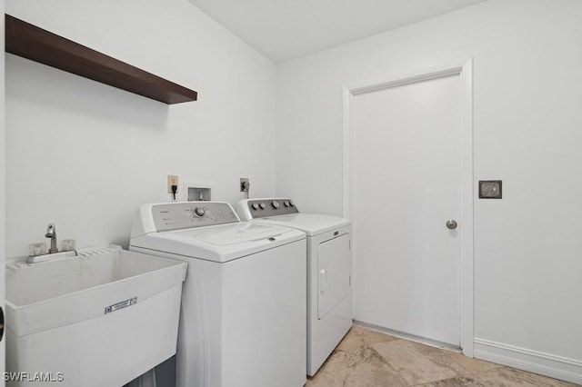 washroom featuring washing machine and clothes dryer, laundry area, and a sink