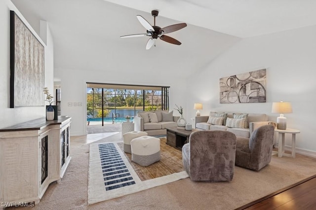 living room with baseboards, high vaulted ceiling, wood finished floors, and a ceiling fan