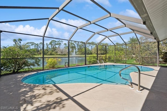 outdoor pool featuring glass enclosure, a patio, and a water view