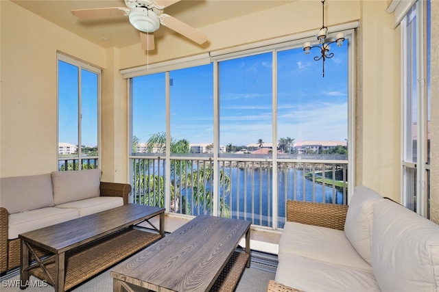 sunroom with a water view and a ceiling fan