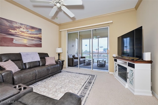 living room featuring carpet floors, crown molding, baseboards, and a ceiling fan