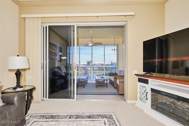 living area featuring carpet floors, a fireplace, crown molding, and ceiling fan