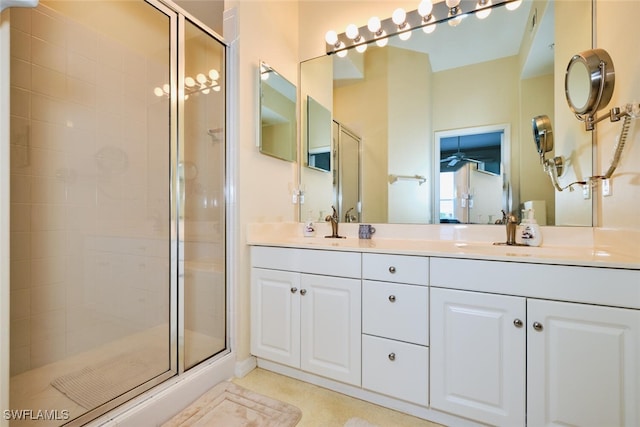 full bath featuring double vanity, a stall shower, and a sink