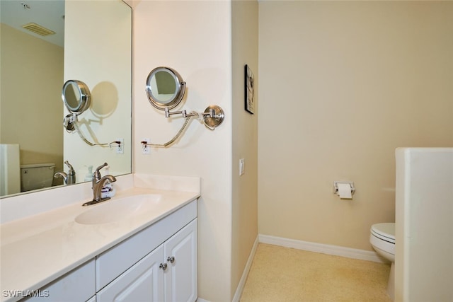 bathroom with visible vents, vanity, toilet, and baseboards