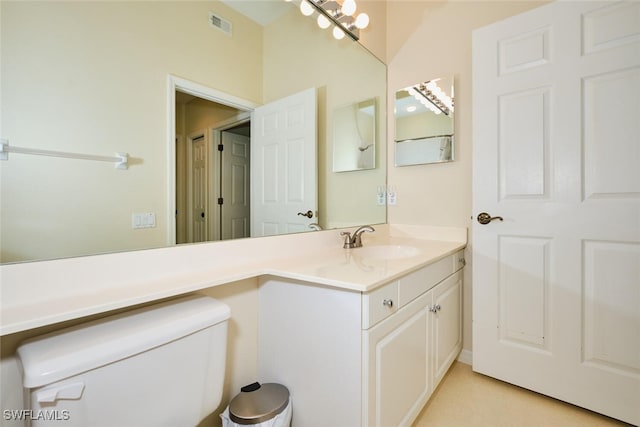 bathroom featuring toilet, vanity, and visible vents