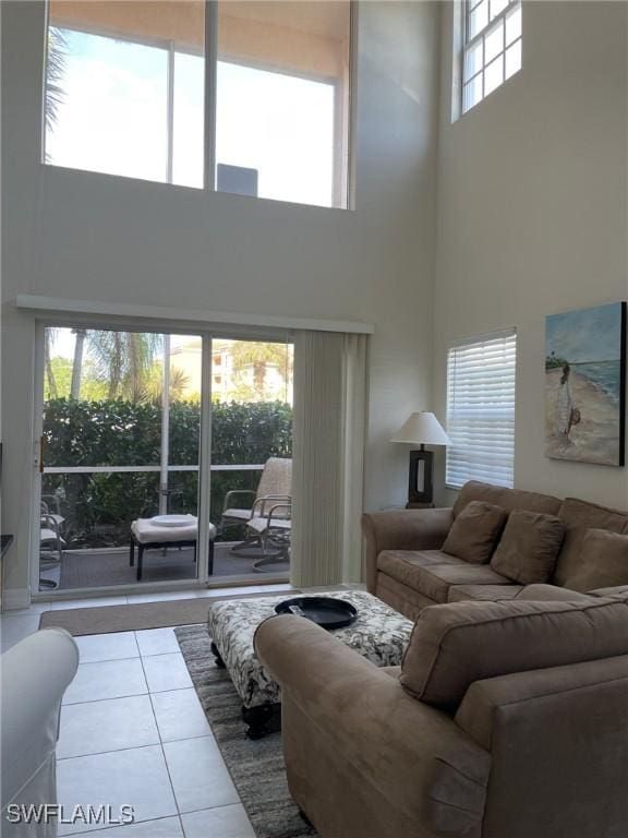 living room with tile patterned flooring and a towering ceiling