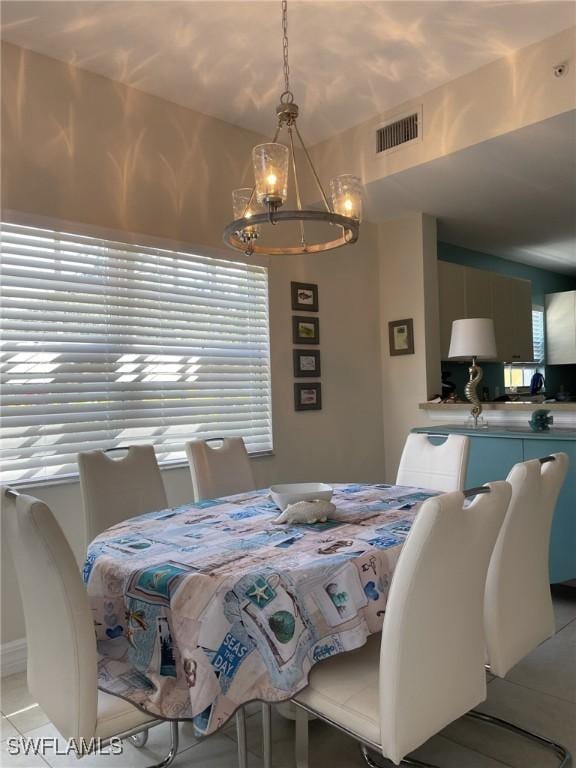 dining space featuring visible vents, an inviting chandelier, and light tile patterned flooring