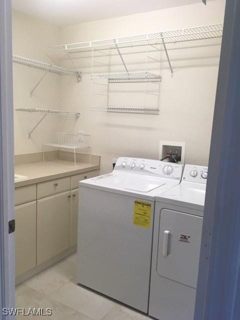 washroom featuring washer and dryer and cabinet space