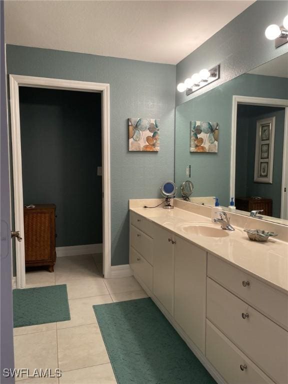 bathroom with vanity, tile patterned floors, and baseboards