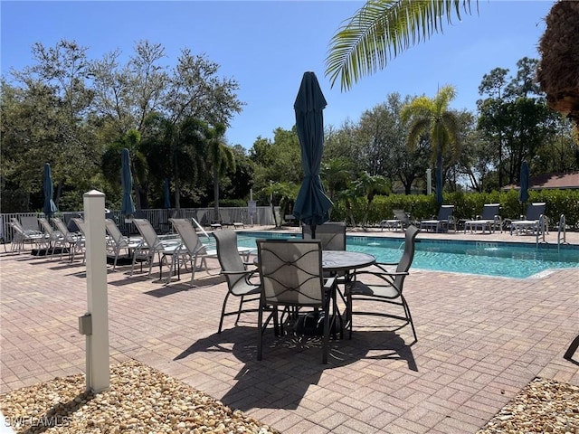 pool with a patio and fence