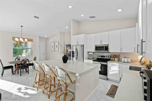 kitchen with visible vents, backsplash, lofted ceiling, stainless steel appliances, and a sink