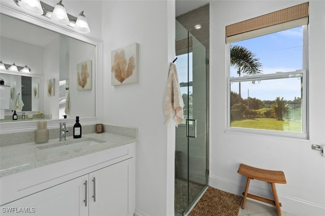 bathroom with baseboards, a stall shower, vanity, and tile patterned flooring