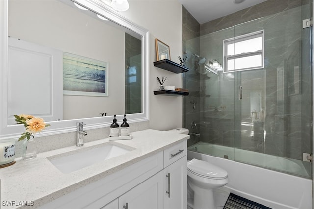 full bath with vanity, toilet, and combined bath / shower with glass door