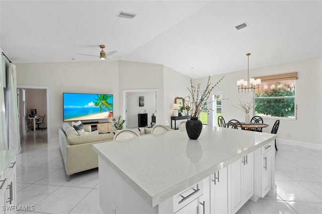 kitchen featuring visible vents, marble finish floor, a center island, and white cabinetry