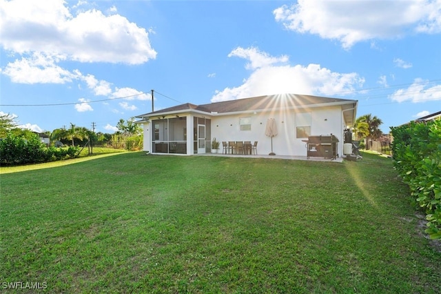 back of property featuring a patio, a lawn, and a sunroom