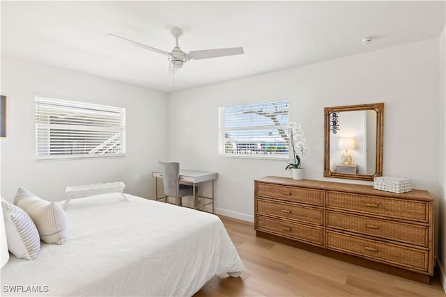 bedroom with light wood finished floors, baseboards, and ceiling fan