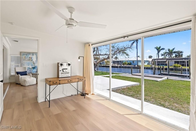 interior space with visible vents, a ceiling fan, and a water view