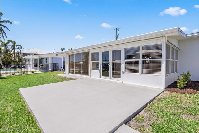 back of property with a patio area, a lawn, and fence